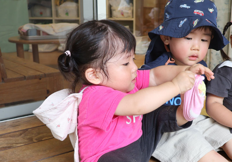 自分で靴下を履く園児